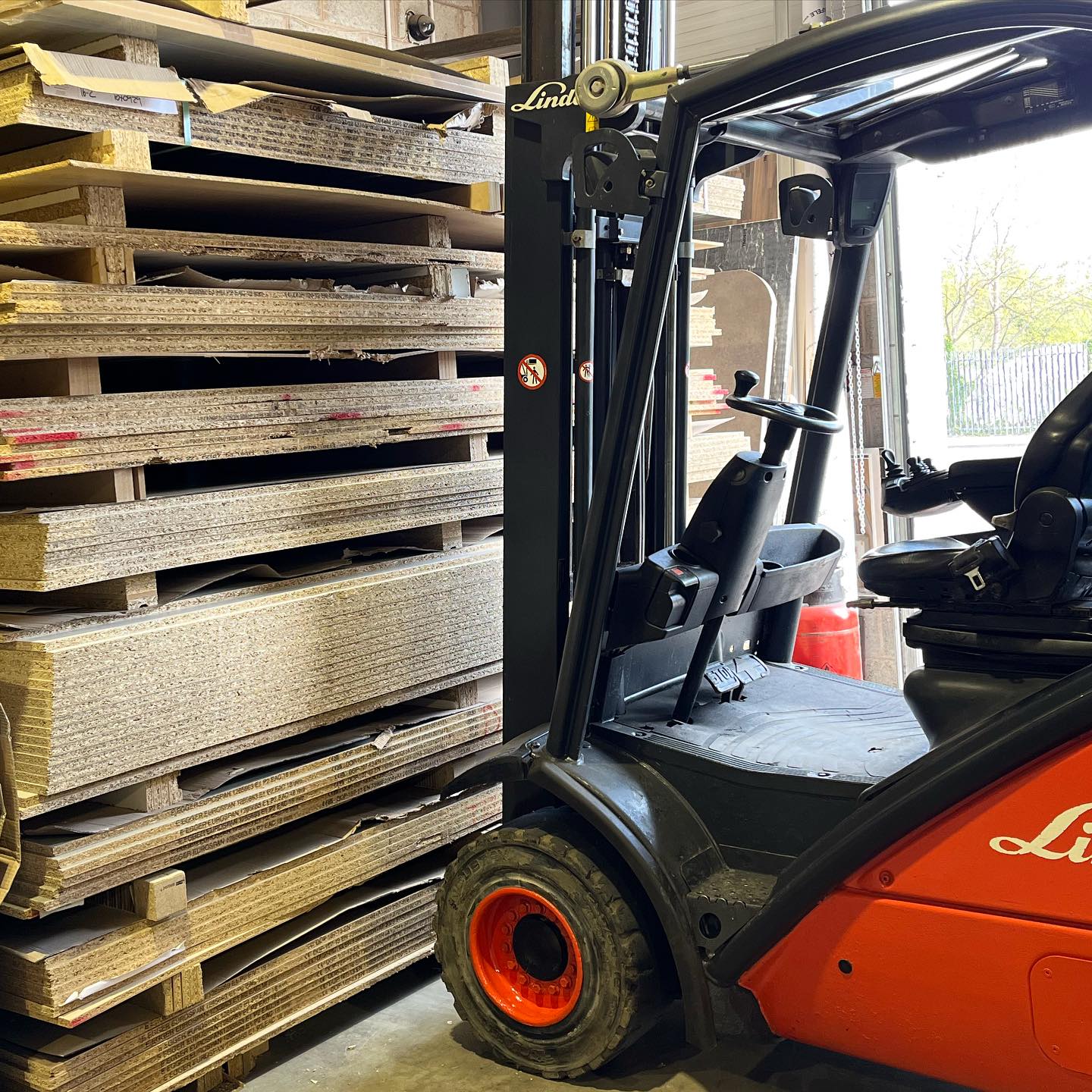 Stacks of board stock and a forklift on the factory floor