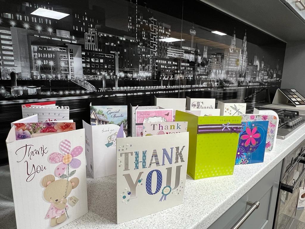 A row of thank-you cards from customers standing on a kitchen worktop